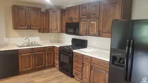 Kitchen with black appliances and light wood-type flooring