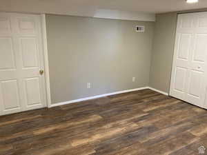 Unfurnished bedroom featuring dark wood-type flooring and a closet
