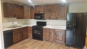 Kitchen with black appliances and light wood finished floors
