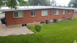 Back of house with brick siding and a yard