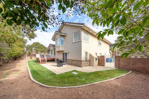 Back of property featuring brick siding, a patio, a fenced backyard, and a gate