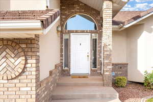 Property entrance with stone siding and stucco siding