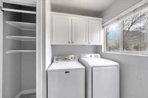 Laundry area featuring cabinet space and separate washer and dryer
