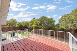 Wooden deck featuring a fenced backyard and a patio area