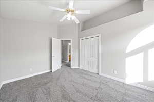 Unfurnished bedroom with carpet flooring, a closet, and a ceiling fan