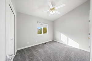 Unfurnished bedroom featuring lofted ceiling, carpet floors, a closet, and a ceiling fan