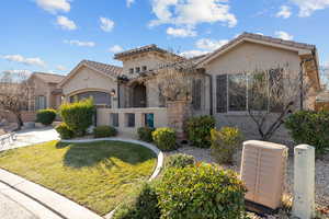 Mediterranean / spanish-style home with stucco siding, a tiled roof, a front lawn, and stone siding