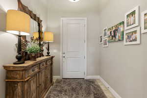 Entryway with baseboards and tile patterned flooring