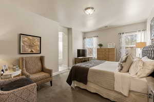 Carpeted bedroom featuring arched walkways and connected bathroom