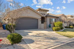 Mediterranean / spanish-style house featuring concrete driveway, stucco siding, a garage, and a tile roof