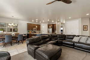 Living area featuring a chandelier, recessed lighting, a ceiling fan, and light carpet