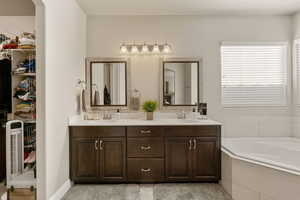 Full bath with double vanity, a bath, and a spacious closet