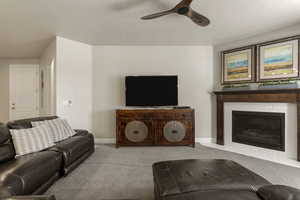 Living area with carpet floors, a fireplace, and ceiling fan
