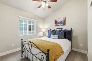 Bedroom with a textured ceiling, ceiling fan, lofted ceiling, and carpet flooring