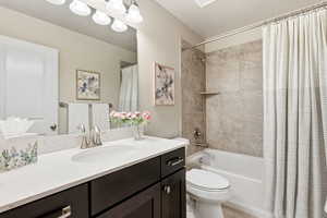 Bathroom featuring shower / bath combo, vanity, and a textured ceiling
