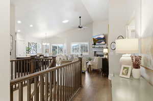 Hallway featuring dark wood-style floors, a chandelier, high vaulted ceiling, and recessed lighting