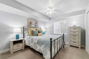 Bedroom with light carpet and a ceiling fan