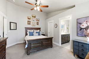 Bedroom featuring light carpet, a ceiling fan, and ensuite bath
