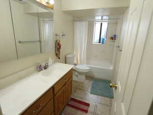 Bathroom featuring vanity and shower / bath combination with curtain