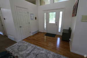 Entrance foyer with wood finished floors and a high ceiling