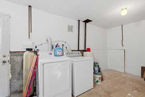 Laundry area featuring concrete floors and washer and clothes dryer