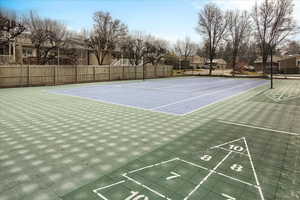 View of tennis court featuring shuffleboard, community basketball court, and a residential view