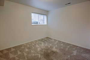 Carpeted empty room with baseboards