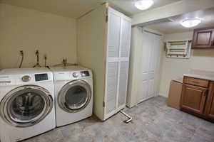 Laundry area with stone finish flooring and independent washer and dryer