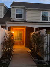 Property entrance featuring brick siding and roof with shingles