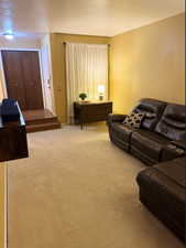 Living area with a textured ceiling and light colored carpet