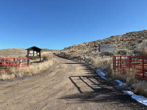 View of dirt / gravel road with a gated entry