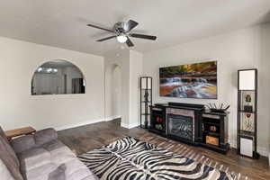 Living room with dark wood-style floors, a textured ceiling, and ceiling fan