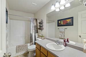 Bathroom featuring shower / bath combo with shower curtain and vanity