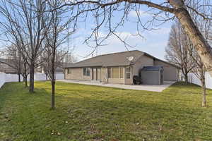 Rear view of house with a fenced backyard, a patio, an outdoor structure, and a shingled roof