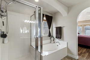 Ensuite bathroom featuring a stall shower and a garden tub