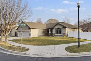 View of front of house featuring stucco siding, driveway, an attached garage, and stone siding