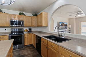 Kitchen with appliances with stainless steel finishes, light countertops, ceiling fan, a textured ceiling, and dark wood-type flooring