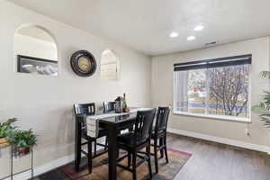 Dining room featuring recessed lighting, dark wood-style flooring, and a textured ceiling