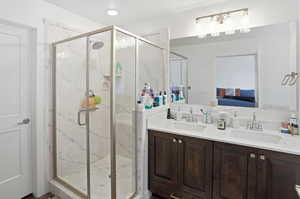 Ensuite bathroom with double vanity and a marble finish shower