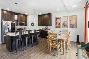 Dining area with light wood-style floors and recessed lighting