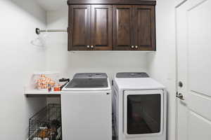 Laundry room featuring cabinet space and washer and clothes dryer