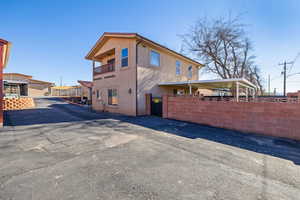 View of side of property with stucco siding and a balcony