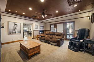 Carpeted living area featuring recessed lighting, a raised ceiling, and ceiling fan