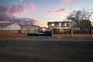 View of front facade with a fenced front yard, a gate, and an outdoor structure