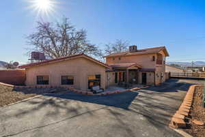 Rear view of house with a fenced backyard, stucco siding, and a tile roof