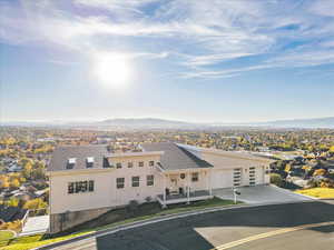 View of front of house with a residential view, concrete driveway, board and batten siding, an attached garage, and a shingled roof