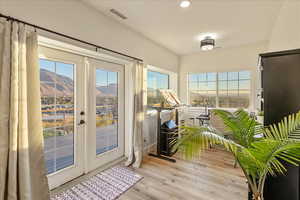 Entryway with a mountain view, wood finished floors, french doors, and recessed lighting
