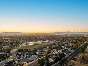 Aerial view of property and surrounding area featuring nearby suburban area and a mountainous background