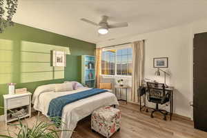 Bedroom featuring wood finished floors, ceiling fan, and a desk