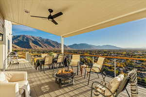 Deck with ceiling fan, a mountain view, a grill, and a fire pit